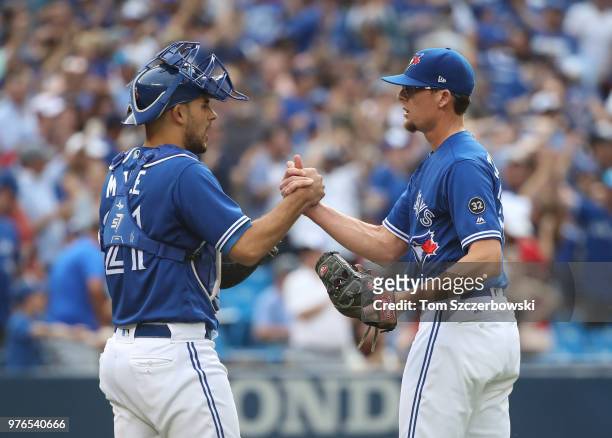 Tyler Clippard of the Toronto Blue Jays celebrates their victory with Luke Maile during MLB game action against the Washington Nationals at Rogers...