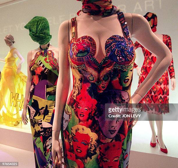 Mannequins display a halter evening gown with Vogue motif and a sleeveless evening gown with Marilyn Monroe and James Dean images and other creations...