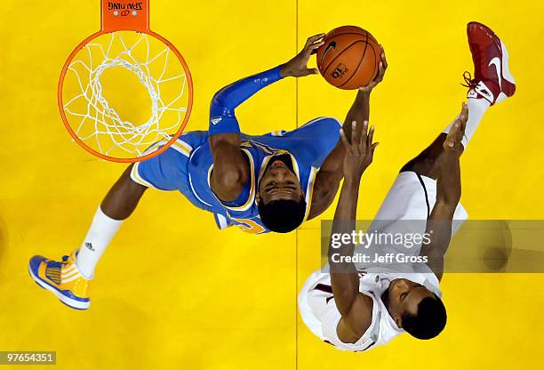 Malcolm Lee of the UCLA Bruins drives to the basket while being defended by Kyle Fogg of the Arizona Wildcats during the Quarterfinals of the Pac-10...