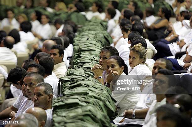 Cuban doctors listen to a speech by Cuban President Fidel Castro in Havana, 04 September 2005, as he extends his offer to send 1100 Cuban doctors...