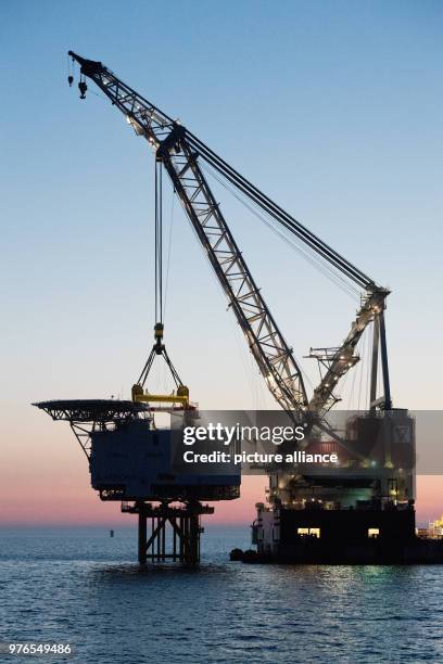 April 2018, Germany, Sassnitz: The crane ship 'Oleg Strashnov' is utilised to install a 4000 tonne transformer platform at the offshore wind farm...