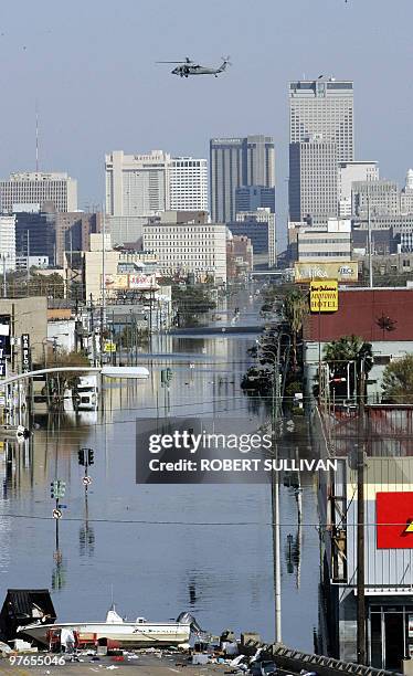 Helicopter flies overhead 06 September 2005 in New Orleans, LA, eight days after Hurricane Katrina devastated the region. Engineers pumped...