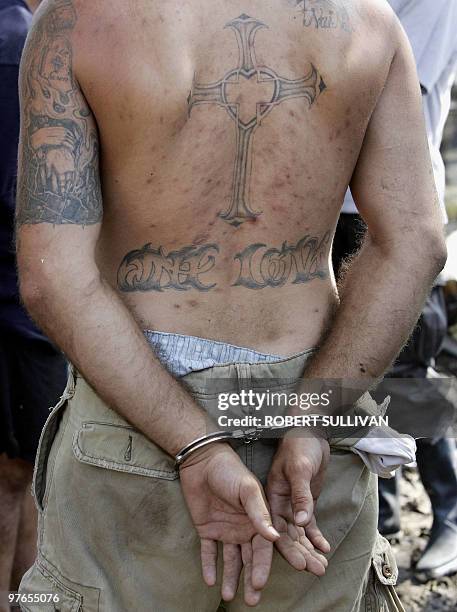 Suspected looter stands handcuffed after being arrested by police 06 September 2005 in New Orleans, LA, eight days after Hurricane Katrina devastated...