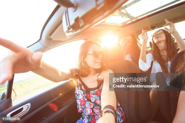 fröhliche freundinnen reisen mit dem auto - auto singen stock-fotos und bilder