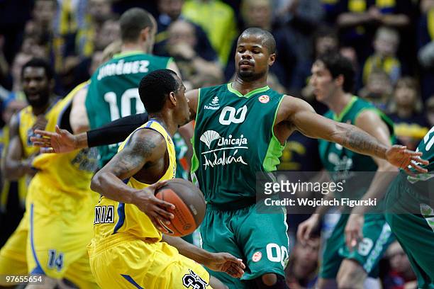 Daniel Ewing, #32 of Asseco Prokom competes with Omar Cook, #00 of Unicaja Malaga in action during the Euroleague Basketball 2009-2010 Last 16 Game 6...