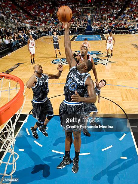 Brandon Bass of the Orlando Magic reaches for a rebound against the Chicago Bulls during the game on March 11, 2010 at Amway Arena in Orlando,...