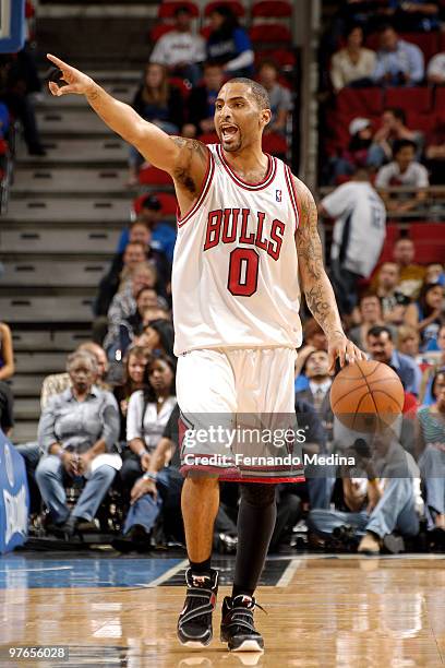 Acie Law of the Chicago Bulls points as he dribbles up the court during the game against the Orlando Magic on March 11, 2010 at Amway Arena in...