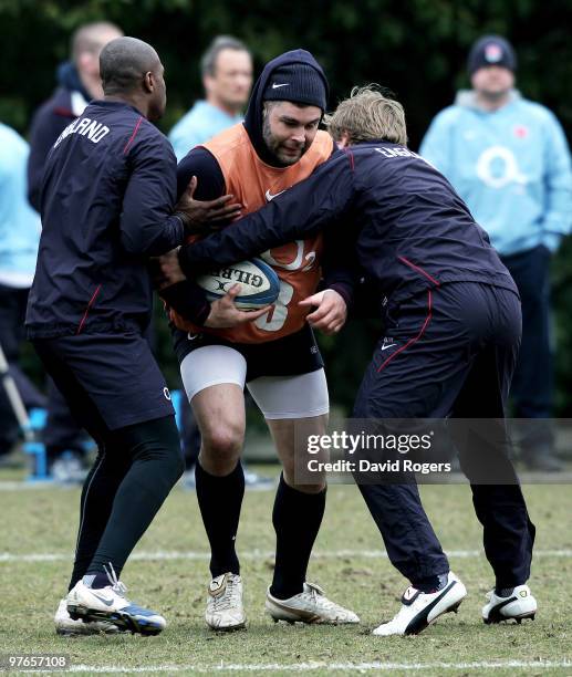 Nick Easter is tackled by Ugo Monye and Mathew Tait during the England rugby union squad training session at Pennyhill Park on March 12, 2010 in...