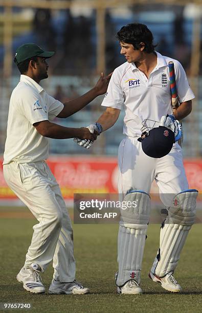 Bangladeshi cricketer Tamim Iqbal congratulates England cricket team captain Alastair Cook after the end of play on the first day of the first Test...