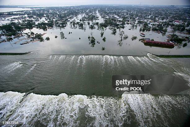 Water spills over a levee along the Inner Harbor Navigational Canal in the aftermath of Hurricane Katrina 30 August, 2005 in New Orleans, Louisiana....