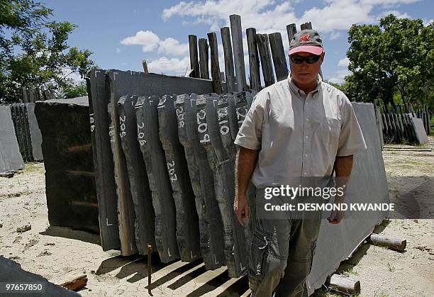 Dave van Breda, chief executive of Zimbabwe's black granite producer Natural Stone Export Company, stands infront of slates of black granite in...