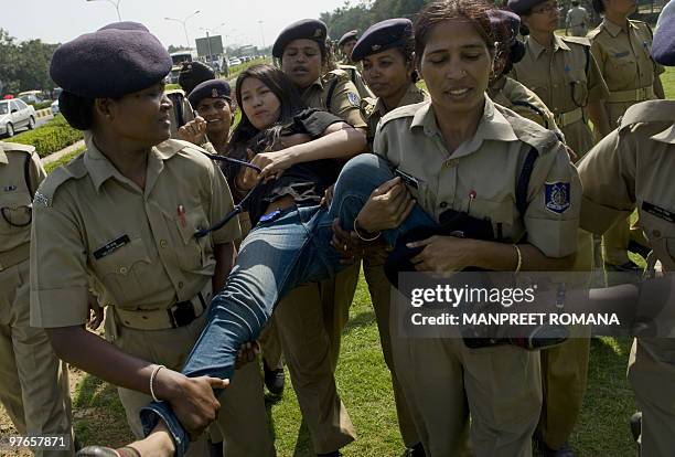 Indian policewomen carry a detained Tibetan in-exile during a protest outside the Chinese embassy in New Delhi on March 12, 2010. Tibetans protested...