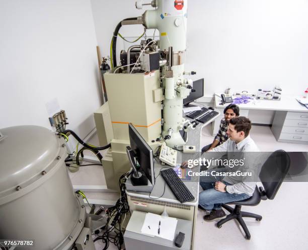 two young scientists using field emission electron microscope - electron microscope micrographs stock pictures, royalty-free photos & images