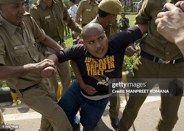 Indian policemen detain a Tibetan in-exile demonstrating outside the Chinese embassy in New Delhi on March 12, 2010. Tibetans protested to mark the...