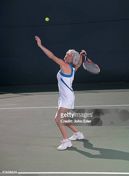 mature female tennis player serving ball - tennis outfit stock pictures, royalty-free photos & images