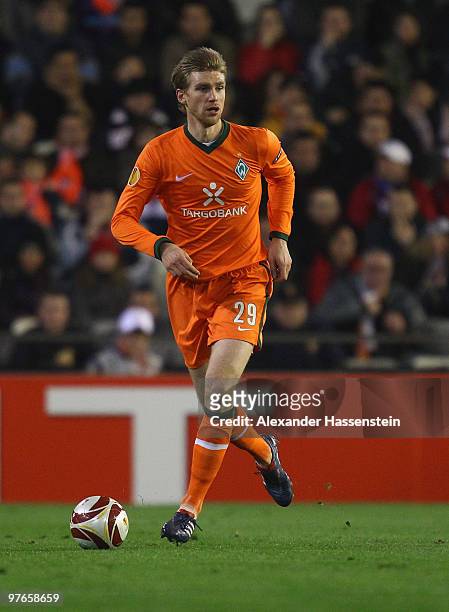 Per Mertesacker of Bremen runs with the ball during the UEFA Europa League round of 16 first leg match between Valencia and SV Werder Bremen at...