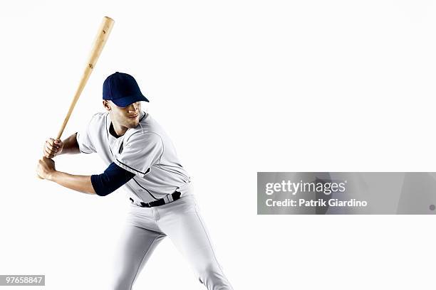 baseball player swinging bat - bate de béisbol fotografías e imágenes de stock