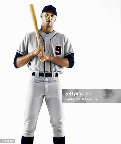 baseball player holding bat - divisa da baseball foto e immagini stock