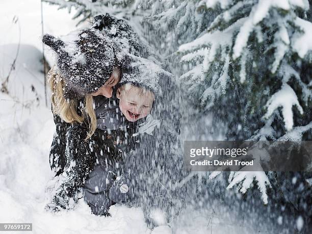 mother and son in snowstorm - david trood stock pictures, royalty-free photos & images