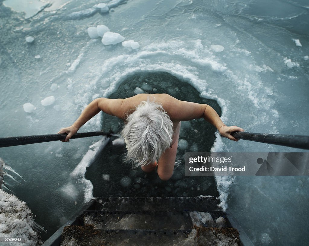 Woman viking going into hole in the ice.