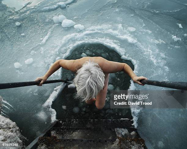 woman viking going into hole in the ice. - david trood stockfoto's en -beelden