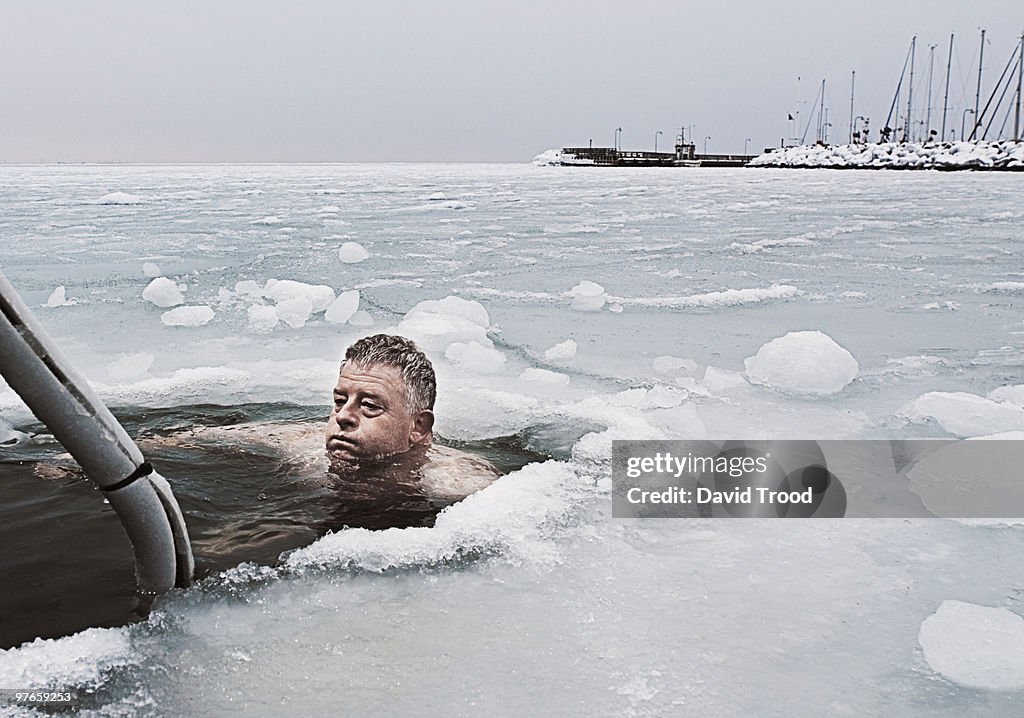Man submerged in frozen sea.