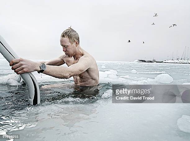viking man bathing in a hole in the icy sea. - david trood stock-fotos und bilder