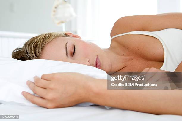 woman sleeping on bed - lying on side stockfoto's en -beelden