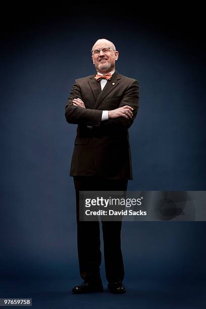man in bow tie with arms crossed - front on portrait older full body foto e immagini stock