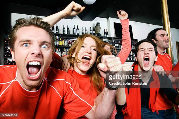 cheering world cup fans celebrate in pub bar - shout photos et images de collection
