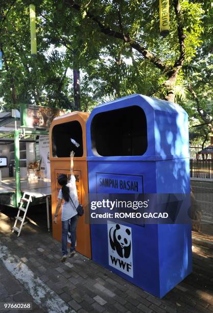 Park visitor throws empty water bottle in the biggest garbage bins in Indonesia following their launching at Jakarta's Ancol family theme park on...