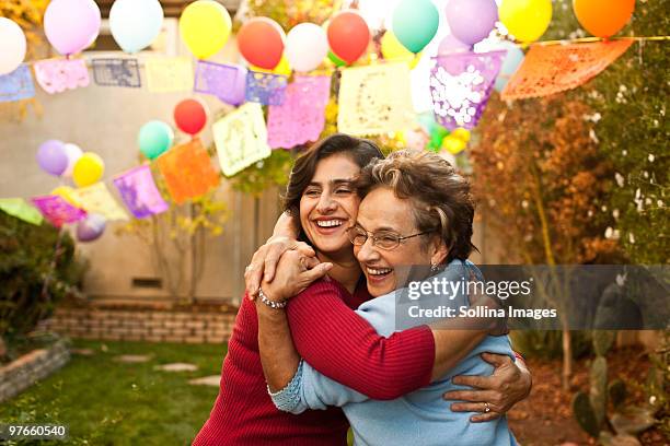 hispanic woman and mother hug - familienfeier stock-fotos und bilder