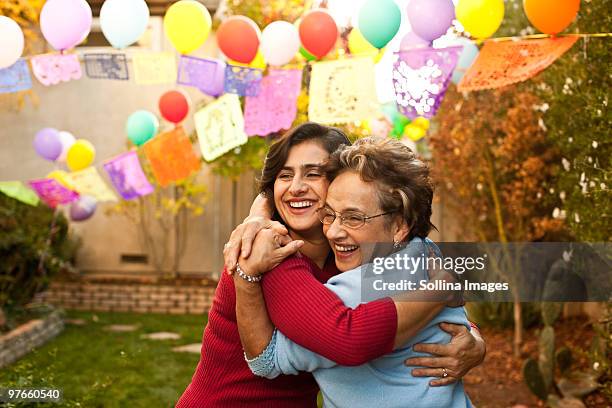 hispanic woman and mother hug - mujeres de mediana edad fotografías e imágenes de stock