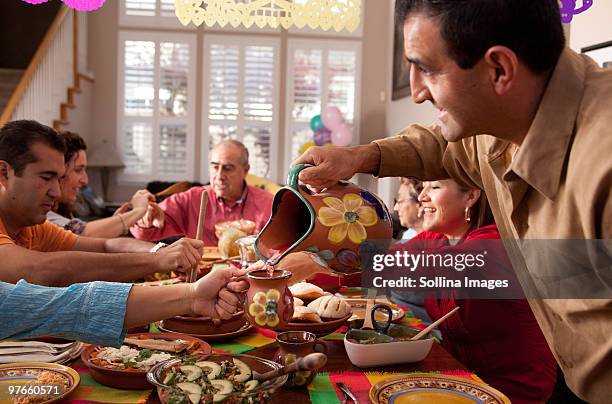 multigenerational mexican family celebrates dinner - mexican people stock pictures, royalty-free photos & images