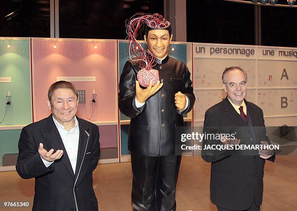 Japanese film director and artist Takeshi Kitano and French culture minister Frederic Mitterrand pose near a statue during a visit of Kitano's...