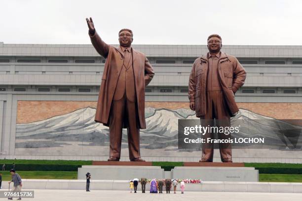 Un colonel de l'armée nord coréenne avec sa famille salue les statues des leaders nord-coréens Kim Il-Sung et Kim Jong-Il à Pyongyang, en Corée du...