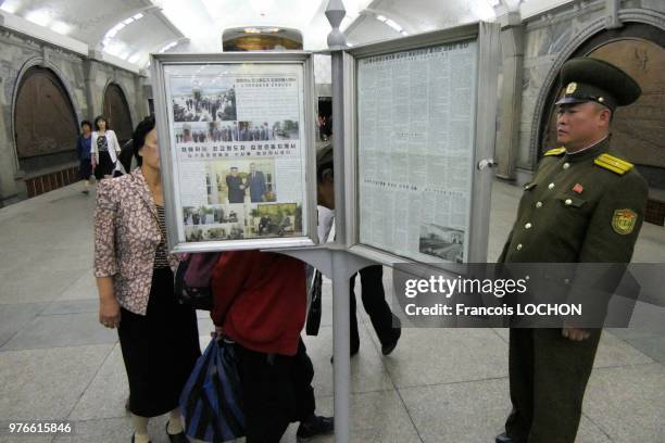 Lecture des informations officielles sur des panneaux publics dans le métro à Pyongyang, en Corée du Nord, le 12 juin 2018.