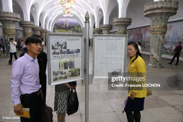 Lecture des informations officielles sur des panneaux publics dans le métro à Pyongyang, en Corée du Nord, le 12 juin 2018.