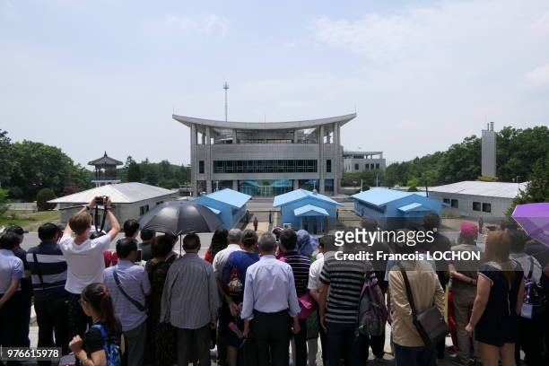 Touristes dans la DMZ observant les baraquements nord coréens, en Corée du Nord, le 13 juin 2018.