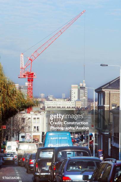 Luffing jib tower crane on a housing project on a busy street in Clapham London .