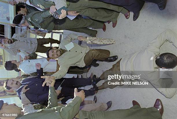 Two Iraqi POW, one crying out "God is Great" and the other lying prone on the ground 24 November 1988, thank God for their return home to Baghdad,...