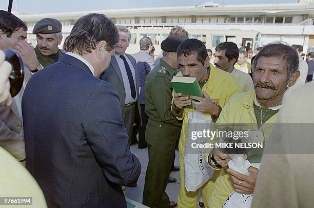 Two Iraqi POW , holding and kissing the Holy Koran 24 November 1988, thank God for their return home to Baghdad, during Iraq-Iran war. The Iraq-Iran...