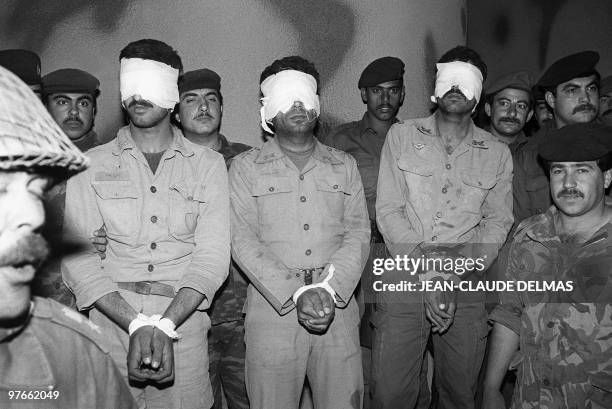 Blindfoilded Iranian POWS are being shown 18 March 1985 to newsmen as they stand by a group of Iraqi soldiers in a makeshift camp near the...