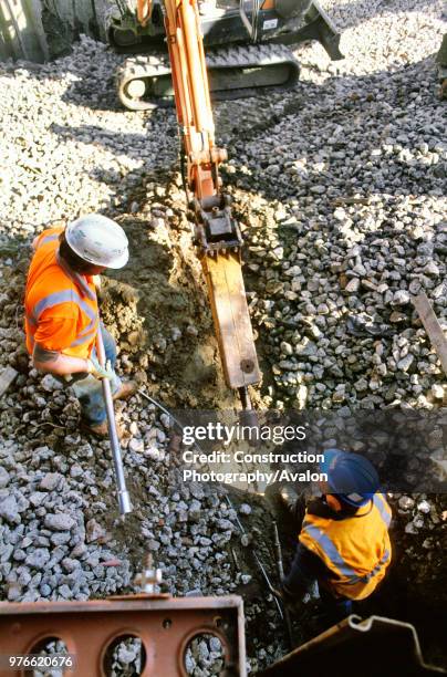 Inserting platyppus anchors for a sheet pile temporary works wall to the Basingstoke canal to reinforce the rail embankment during overbridge...