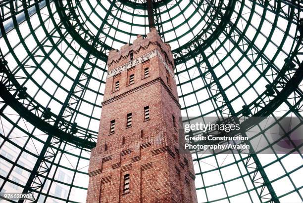 Victorian lead shot factory and tower are preserved beneath a conical skylight above shops and station entrance at Melbourne Central railway station...