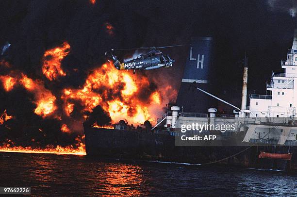 Navy helicopter from the USS CHANDLER moves in to rescue crew members aboard the Cypriot flagged 232-thousand ton tanker Pivot loaded with Saudi...