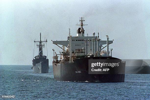 The reflagged tanker Gas King loaded with Kuwaiti crude is escorted December 28, 1988 by the U.S. Guided missile frigate, USS Gallery towards the...