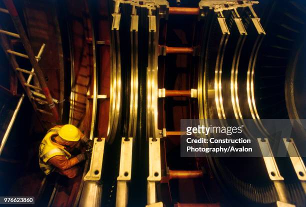 On site assembly of main gas power turbine for new power station in Spalding, East Anglia, United Kingdom The technician checks tolerances on the...