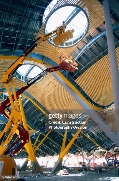 Access platform Worker on a cherry picker Working from telescopic platforms on the bamboo interior cladding for the ceiling of the main concourse at...