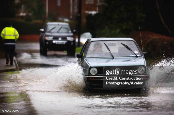 Car driving along flooded road, Stonehouse, Gloucestershire, UK, Jan 2008.